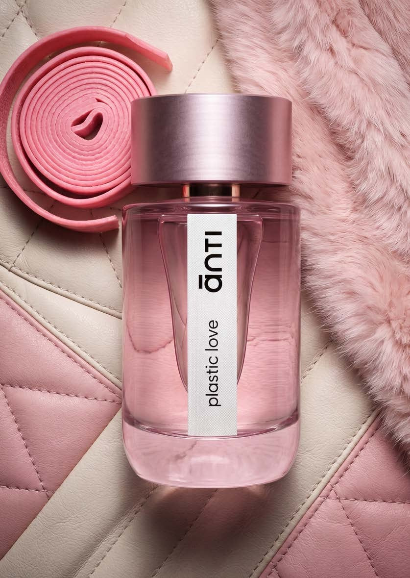 plastic love by ānti, a pink 100ml fragrance bottle resting on quilted leather beside a coiled pink belt and pale pink fur